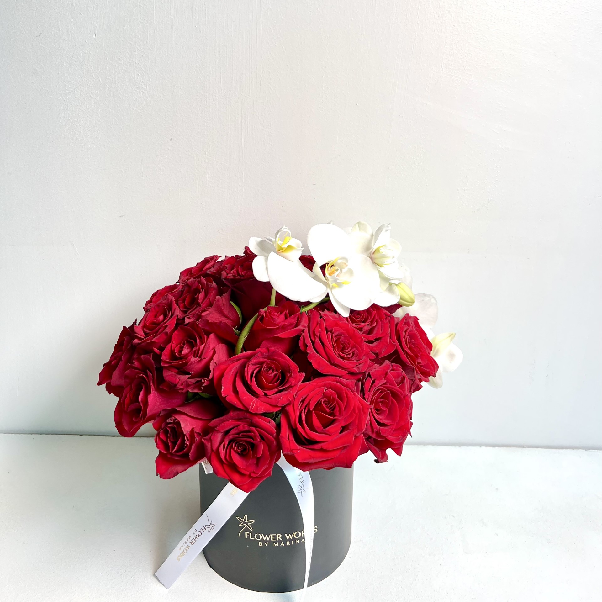RED ROSES AND WHITE PHALEONOPSIS IN A BLACK BOX